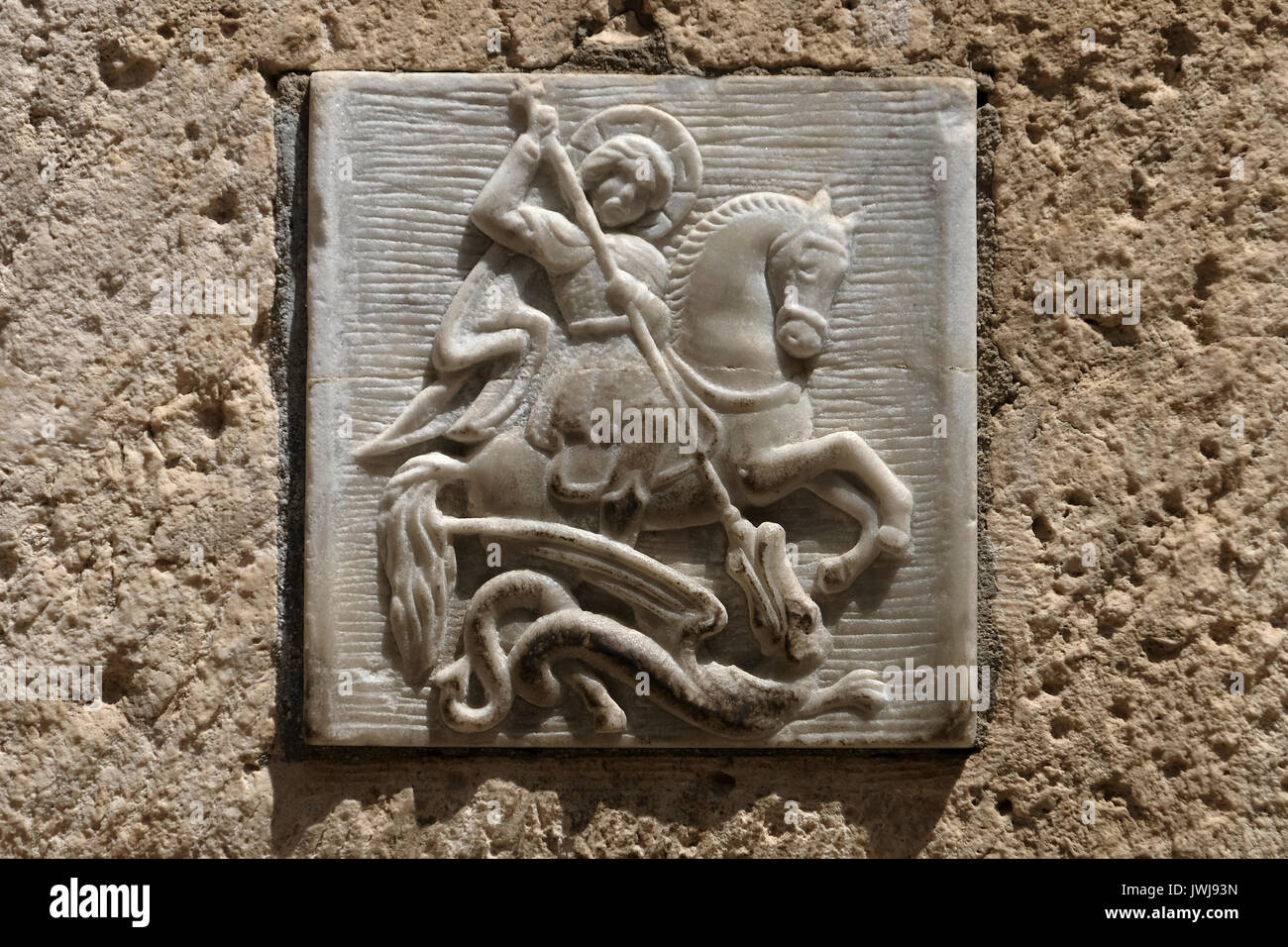 A carved figure depicting an orthodox Christian legend in which Saint George slays a dragon that demanded human sacrifices at entrance to the St. George Monastery in Saint Francis street in the Christian Quarter old city East Jerusalem Israel Stock Photo