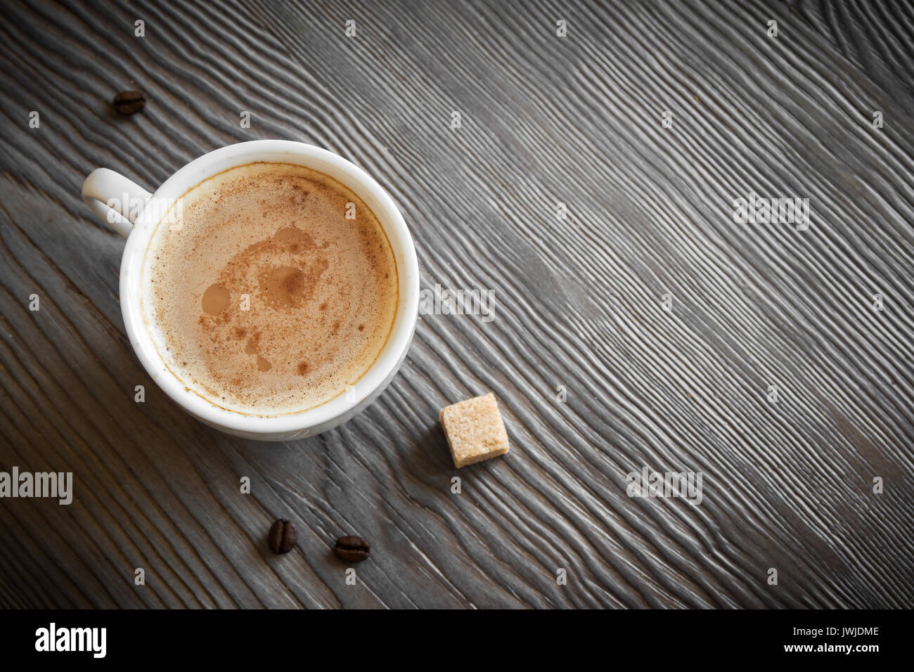 Cup of coffee with cinnamon, brown sugar and coffee beans. Cappuccino coffee, tint image. Stock Photo