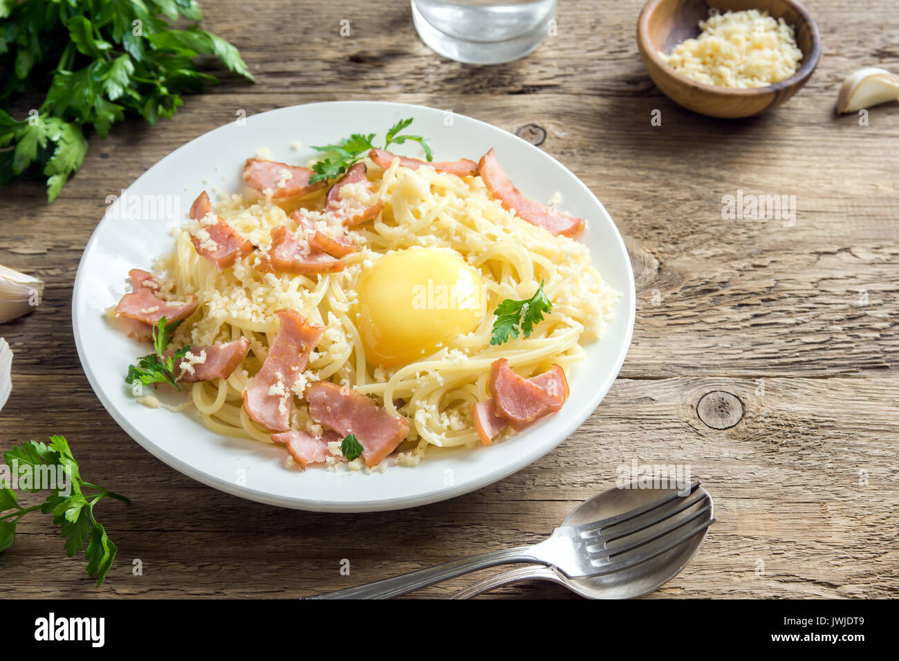 Spaghetti carbonara pasta with egg sauce, bacon and grated parmesan cheese  - homemade healthy italian pasta on rustic wooden background Stock Photo