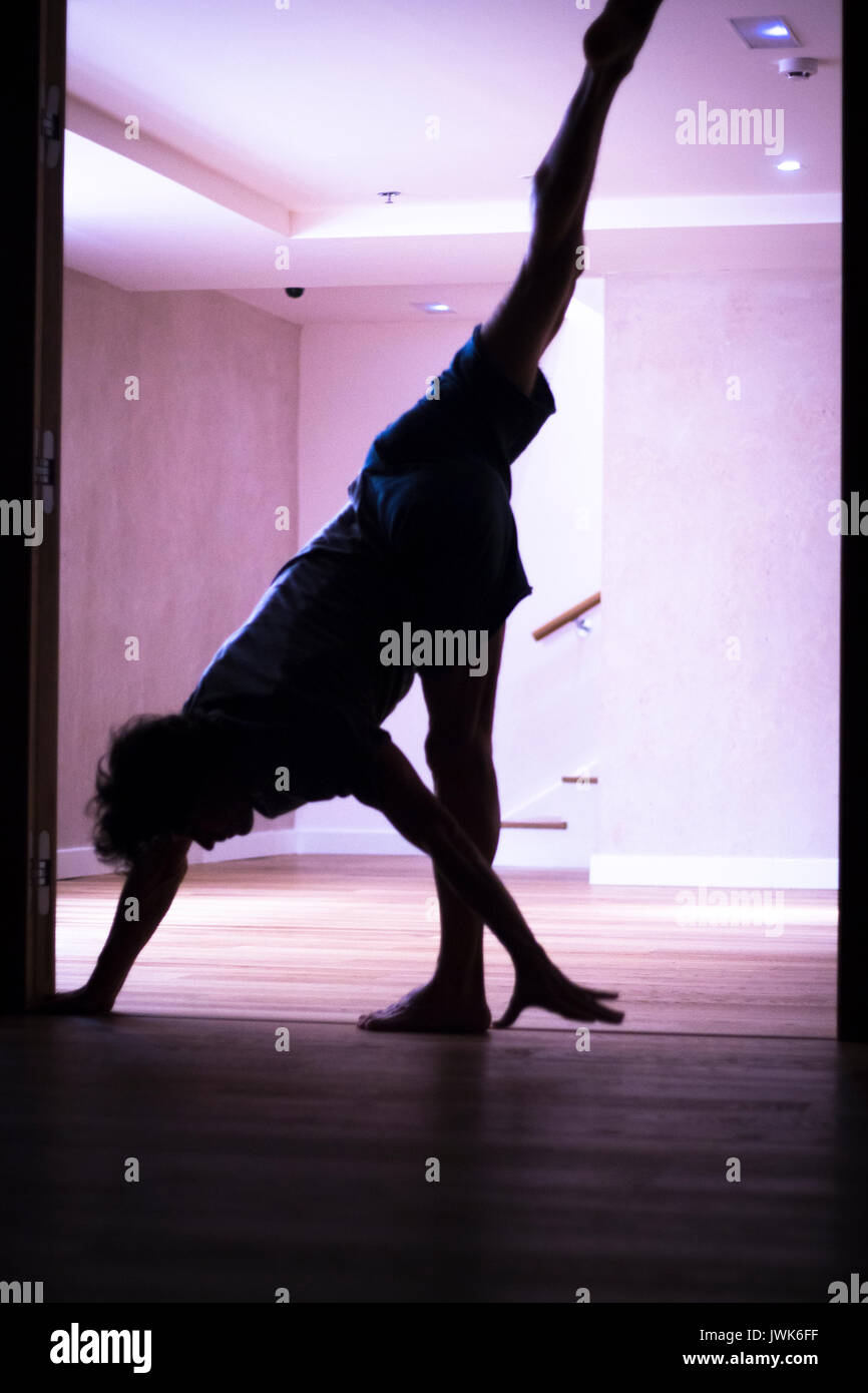 Male yoga teacher doing handstand inversion alisthenics and yoga asana