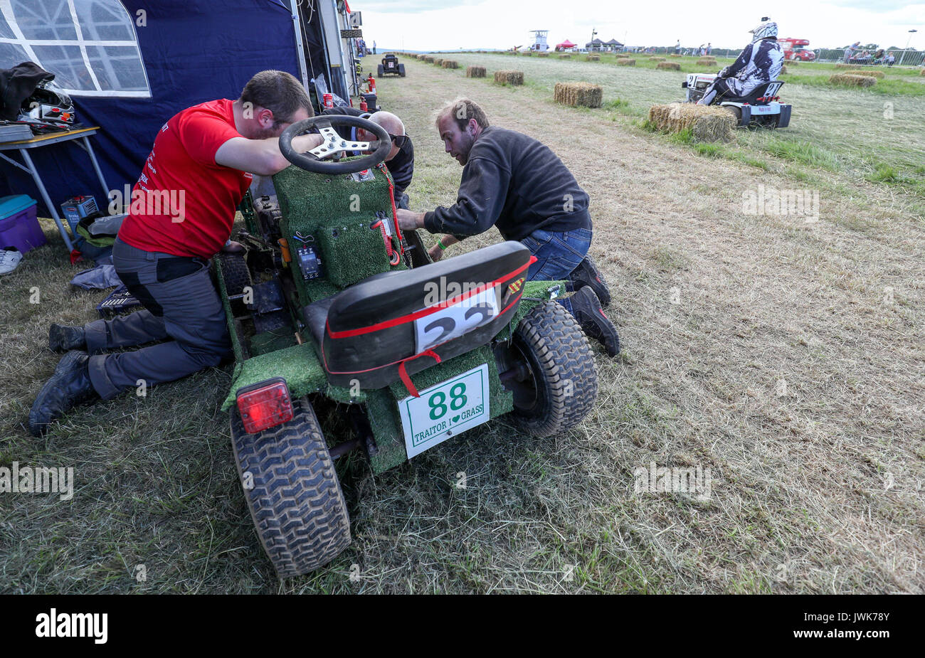 Adjustments are made to a lawnmower during qualifying for the British Lawn Mower Racing Association 12 hour endurance race at Five Oaks near to Billingshurst in West Sussex. Stock Photo