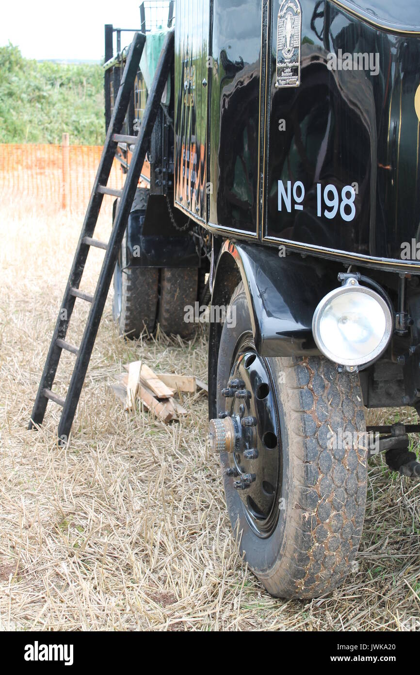 Ladder leaning against the side of a black historic vehicle at a vintage machinery rally in Devon. Stock Photo