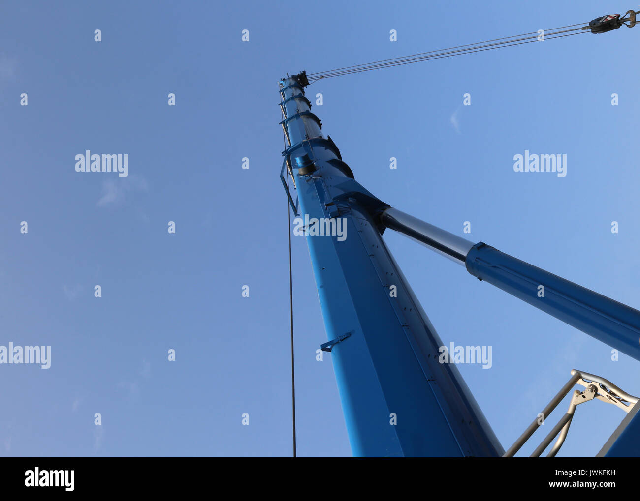 Immense hydraulic arm of a powerful crane for lifting heavy loads at an industrial site Stock Photo