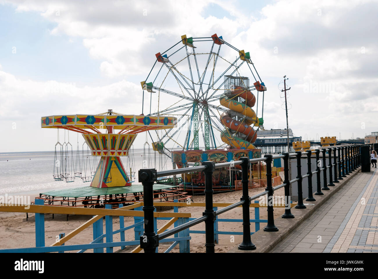 Seaside, Carnival, Fair, Amusement Rides on the Beach, Ferris Wheel, Slide, Swing Ride, Empty, Derelict, Railings, England, Cleethorpes, Sand, Pathway Stock Photo