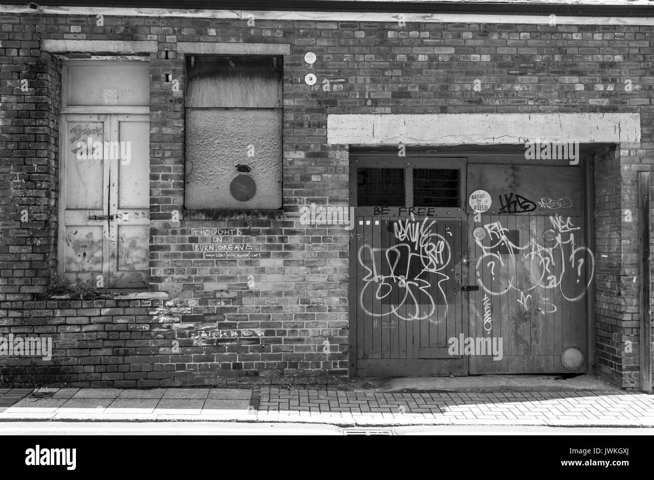 Abandoned Building, Derelict, Deserted, Sealed Off, Boarded Up Windows, Rundown, Urban Area, Brick Exterior, In Ruins, Unoccupied Location Graffiti Stock Photo