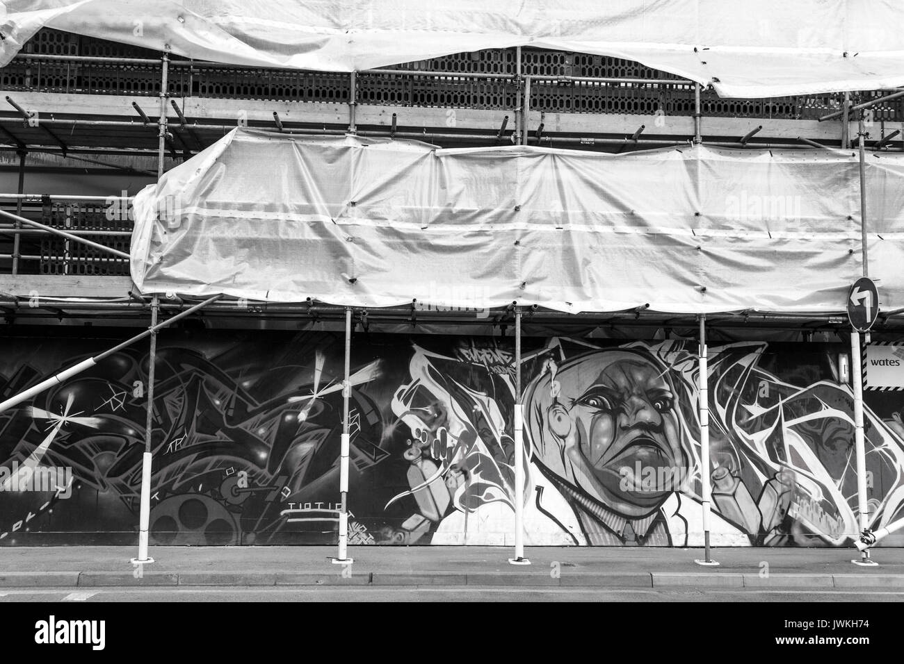 Building Graffiti Artwork, Scaffolding, Street Art Black and White Image, Person Cartoon Character Painted, Fixing, Workers Platform, Closed Off Stock Photo