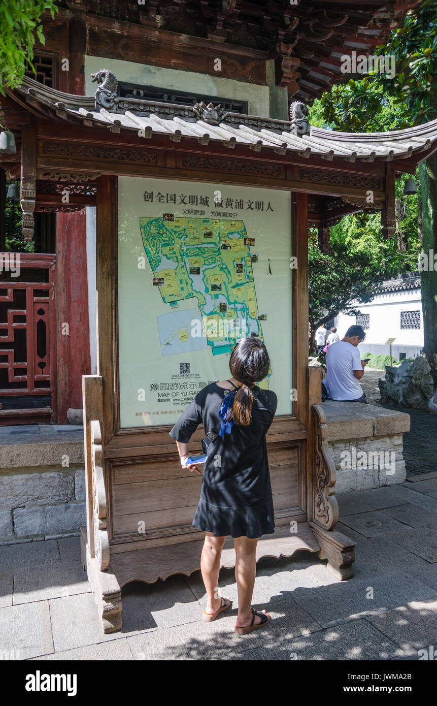 A Lady Reads A Map Of Yuyuan Gardens In Shanghai China Stock