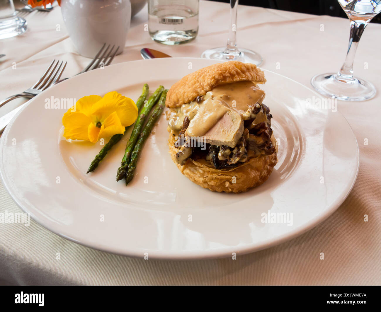 A delicious appetizer of asparagus, mushrooms, foie gras on a white plate on a table Stock Photo