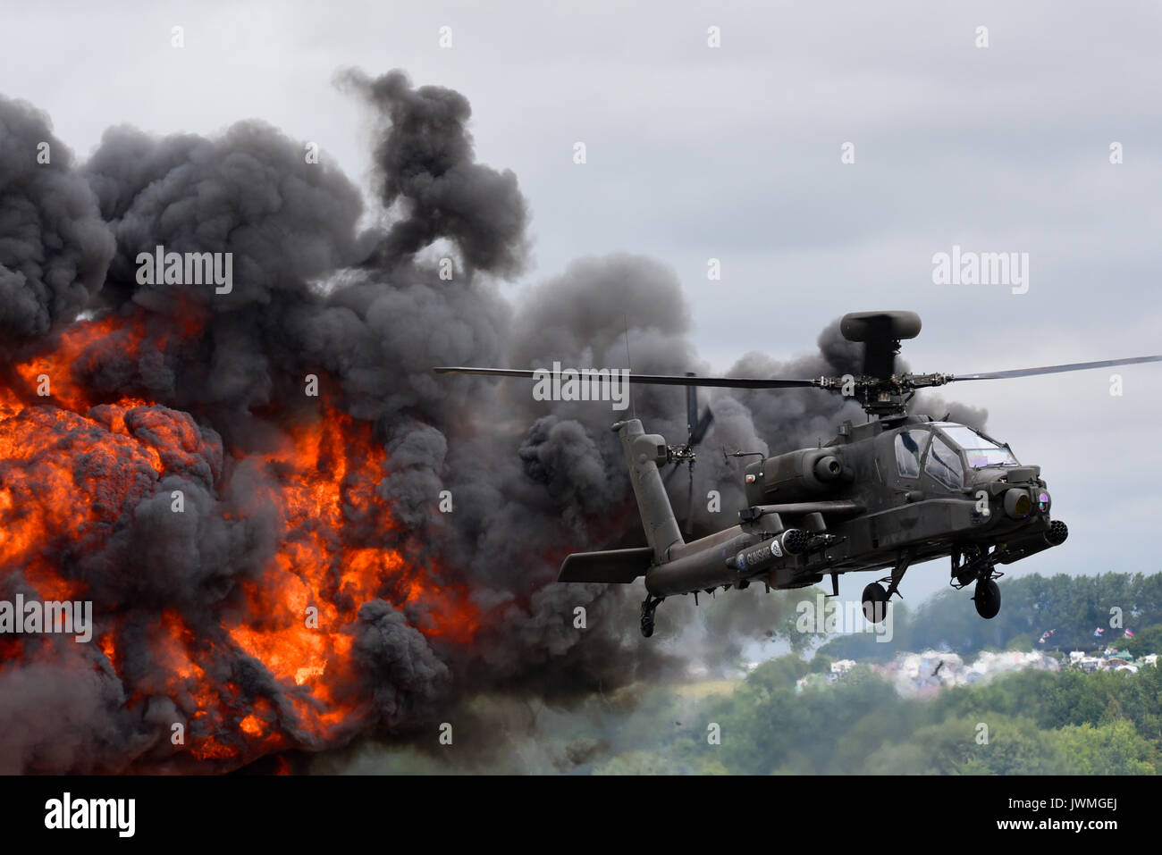 British Army Agusta Westland AH-64 Apache AH1 attack helicopter with exploding pyrotechnics at RIAT airshow Stock Photo