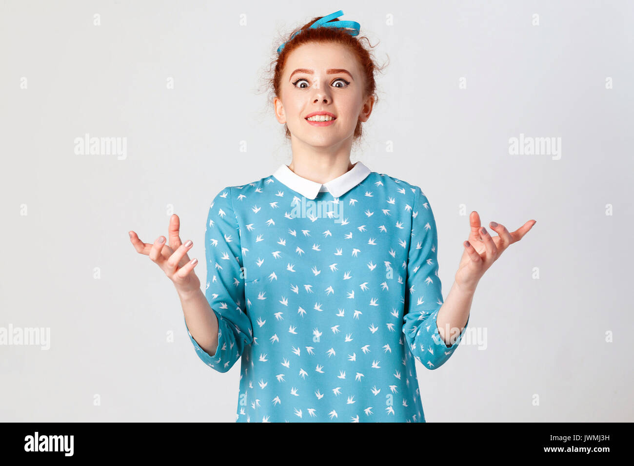 Body language. The young surprised and astonished caucasian girl gesturing in full disbelief, shrugging her shoulders, having shocked expression, open Stock Photo