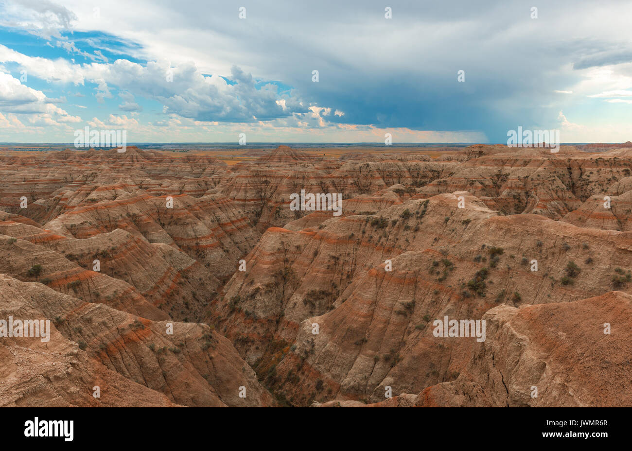 Landscape in Badlands National Park with its rock stratifications and a thunderstorm on the way at sunset, South Dakota, United States of America, USA. Stock Photo