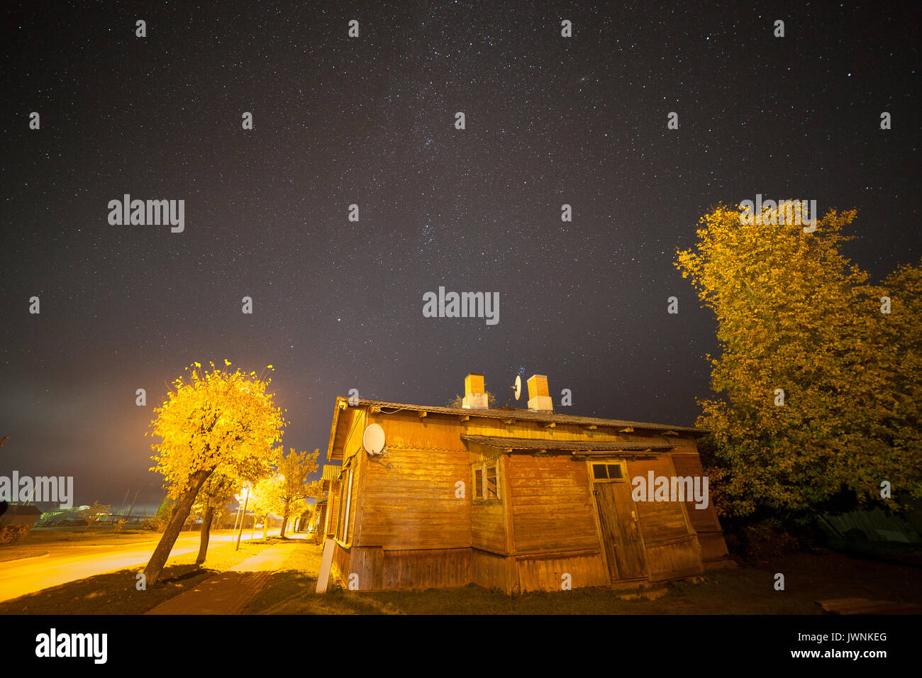 Starry sky over small town street with old wooden houses. Autumn time, Stock Photo