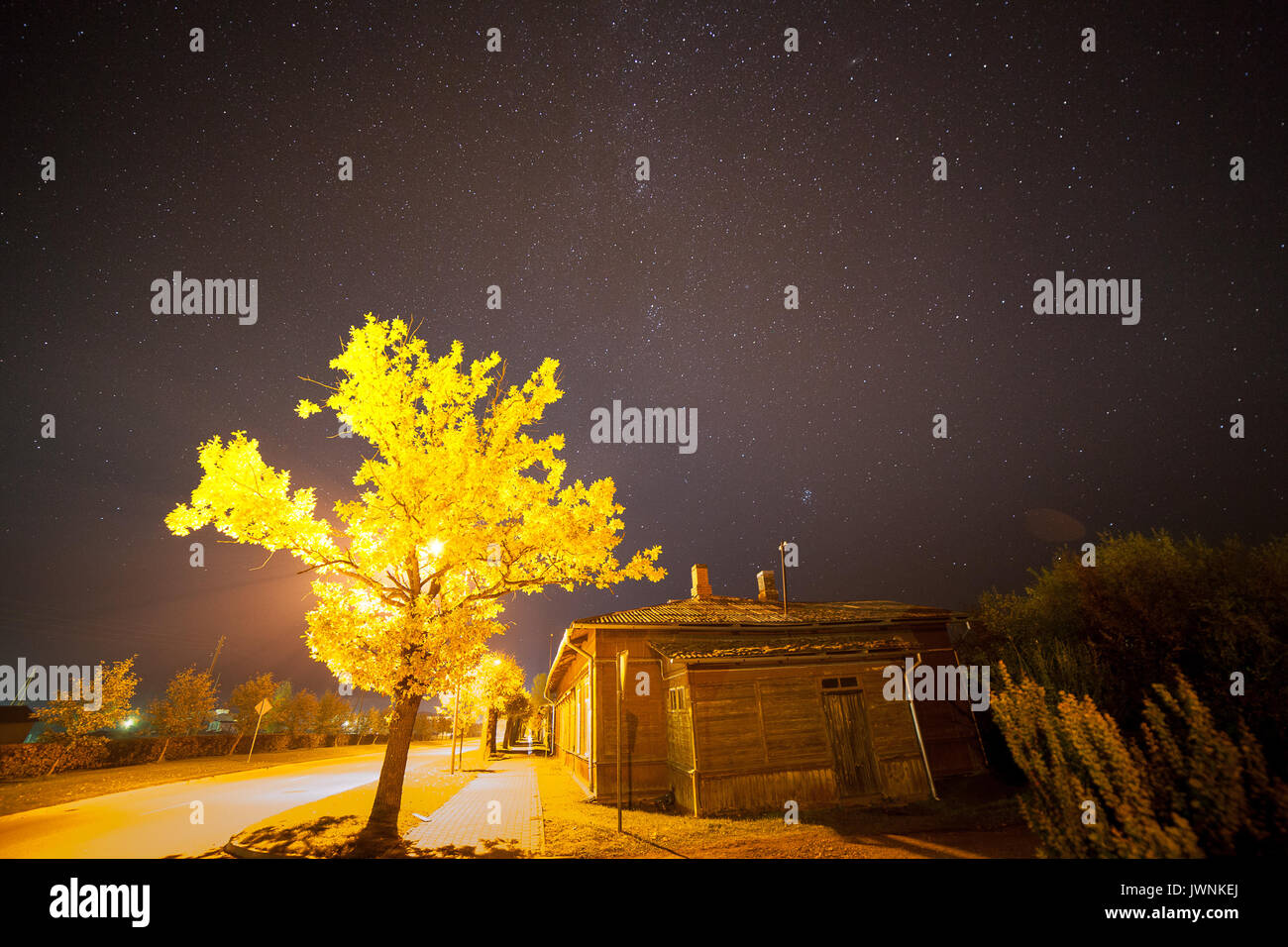 Starry sky over small town street with old wooden houses. Autumn time, Stock Photo