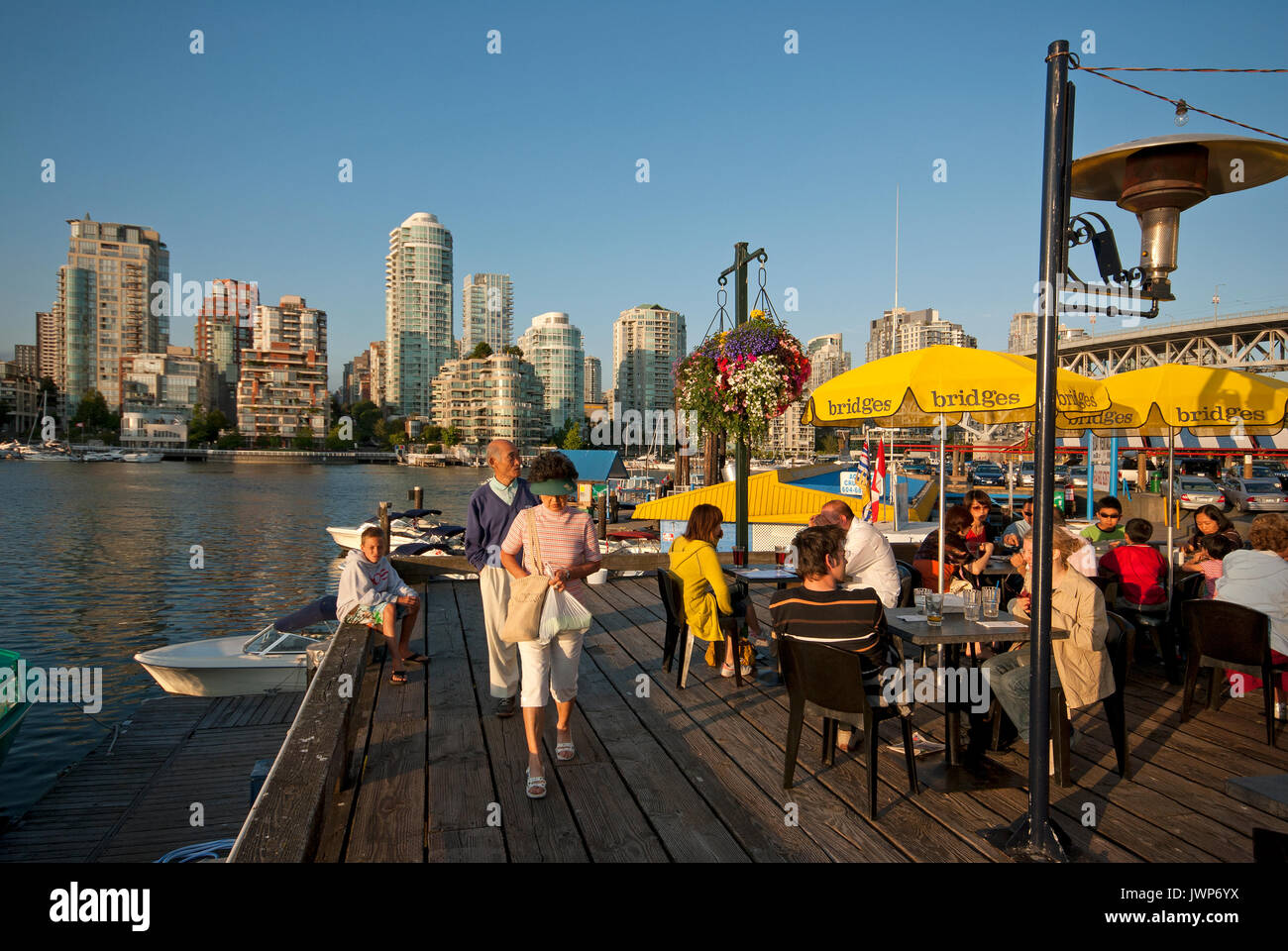 People dining on the terrace of the Bridges Restaurant, Granville Island, skyscrapers in the background, Vancouver, Canada Stock Photo