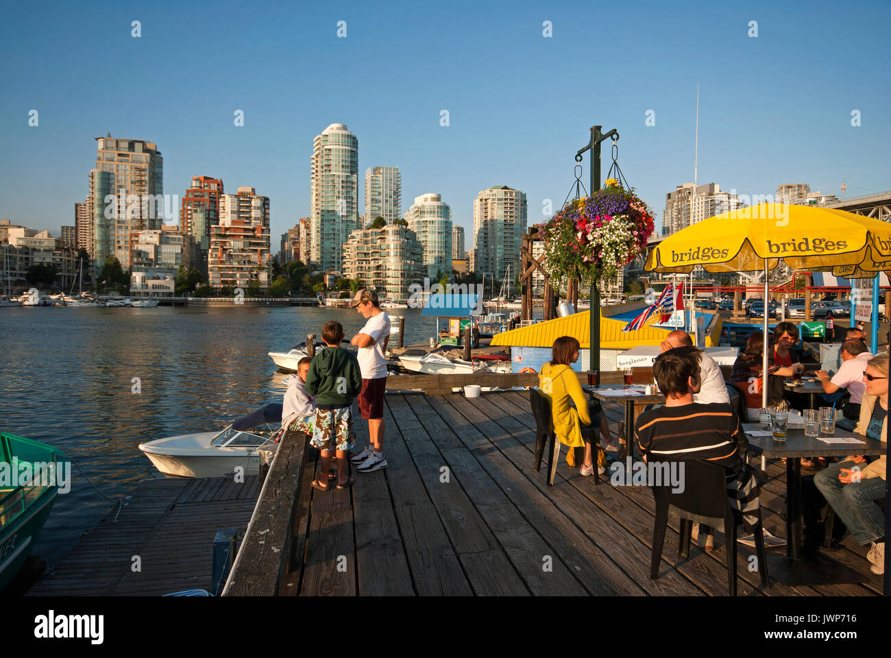 People dining on the terrace of the Bridges Restaurant, Granville Island, skyscrapers in the background, Vancouver, British Columbia, Canada Stock Photo