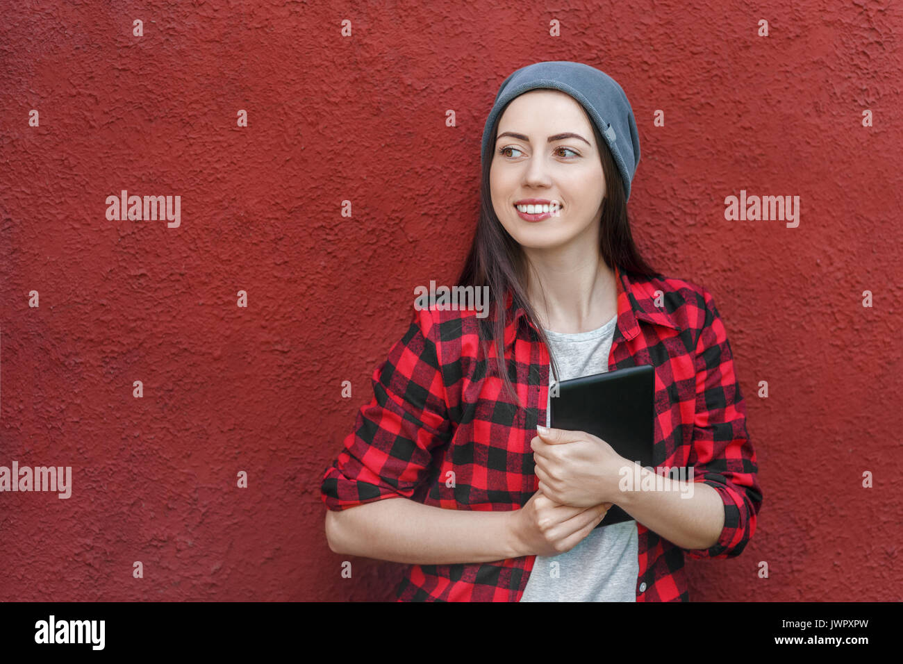 Portrait of a cheerful young woman holding tablet computer. Smiling girl with digital tablet outdoors, copy space, social networking concept Stock Photo