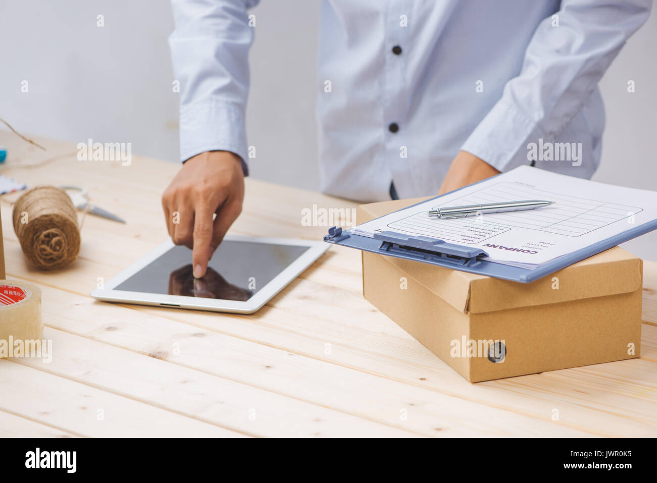 Male deliverer with tablet on work place in post office Stock Photo - Alamy
