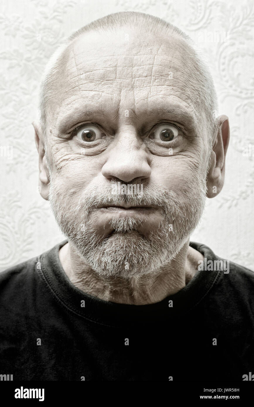Black and white portrait of a funny and crazy caucasian man making faces with eyes round like balls and puffy cheeks Stock Photo