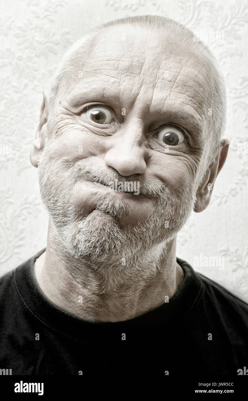 Black and white portrait of a funny and crazy caucasian man making faces with eyes round like balls and puffy cheeks Stock Photo