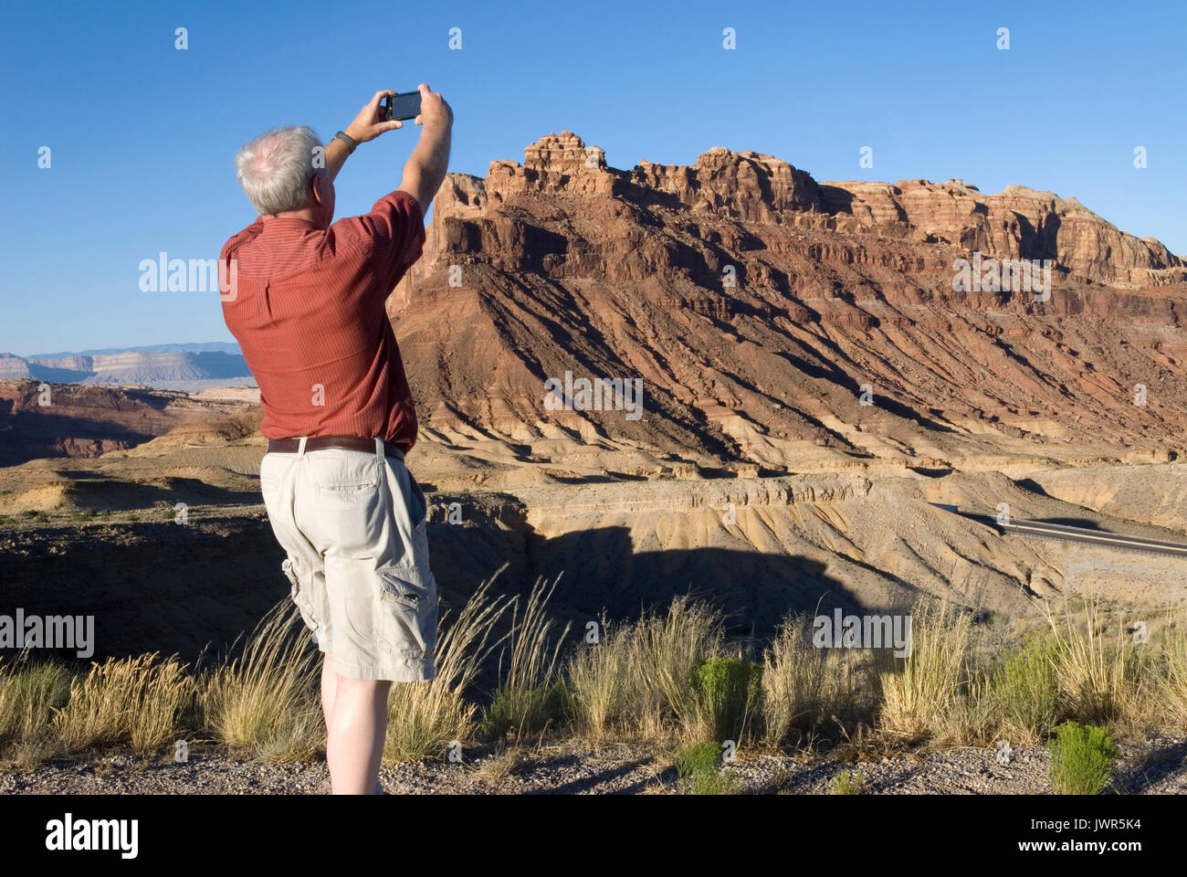 Caucasian Senior Male (age 60-70) taking photo with cellphone at Castle Valley, Utah USA Stock Photo