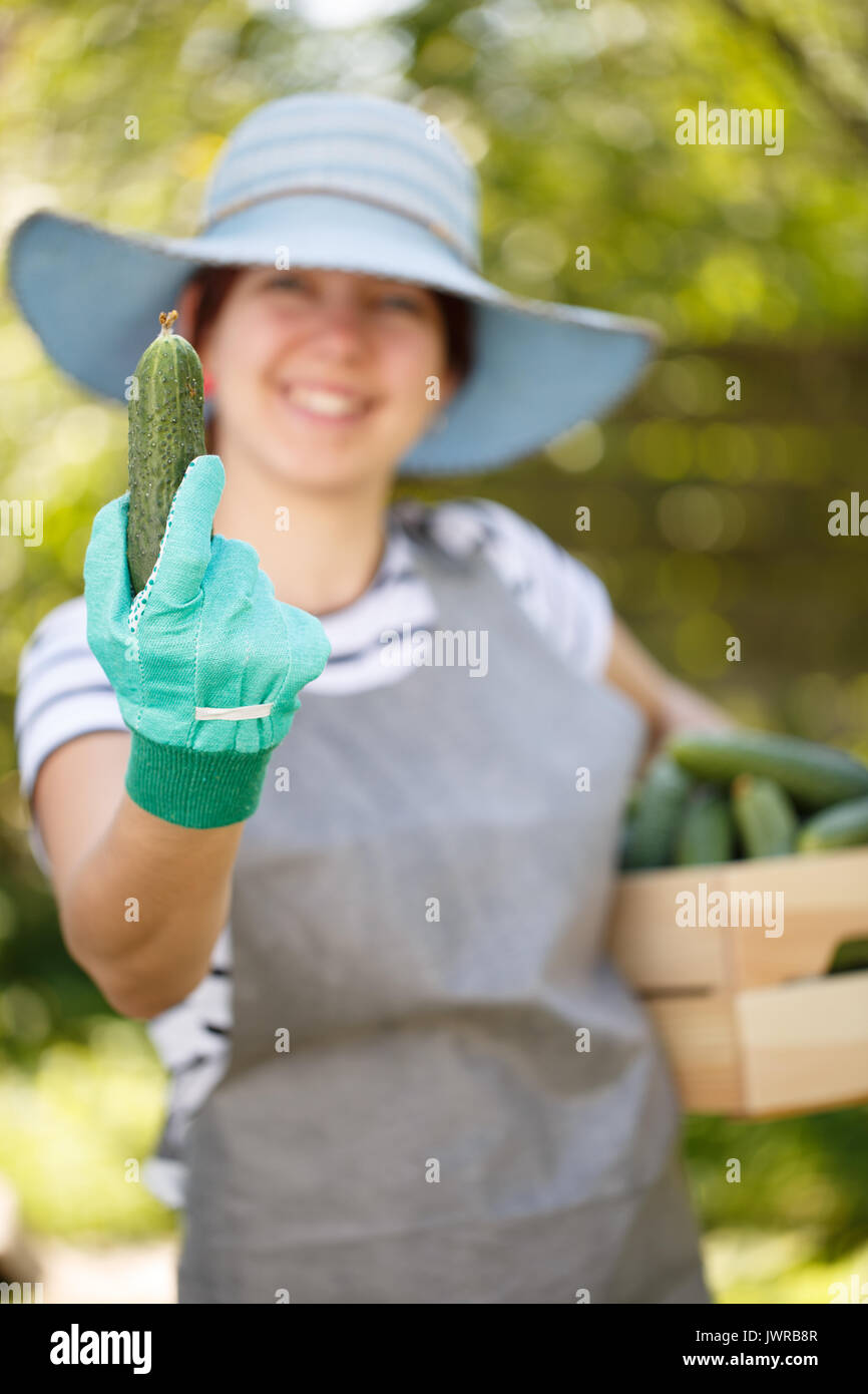 Girl holds cucumber in hand Stock Photo - Alamy