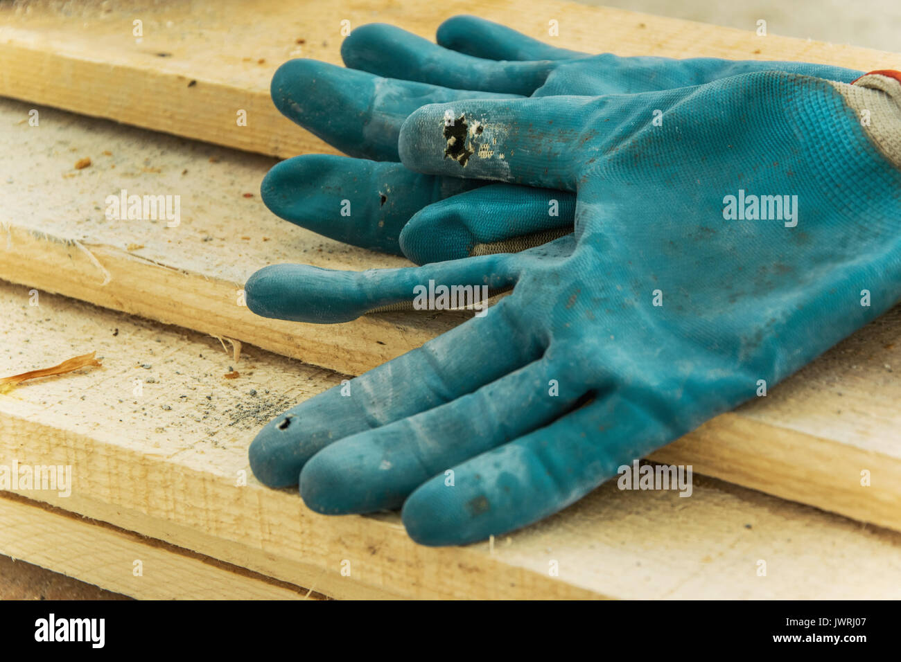 Workers gloves on a wood carpentry board Stock Photo