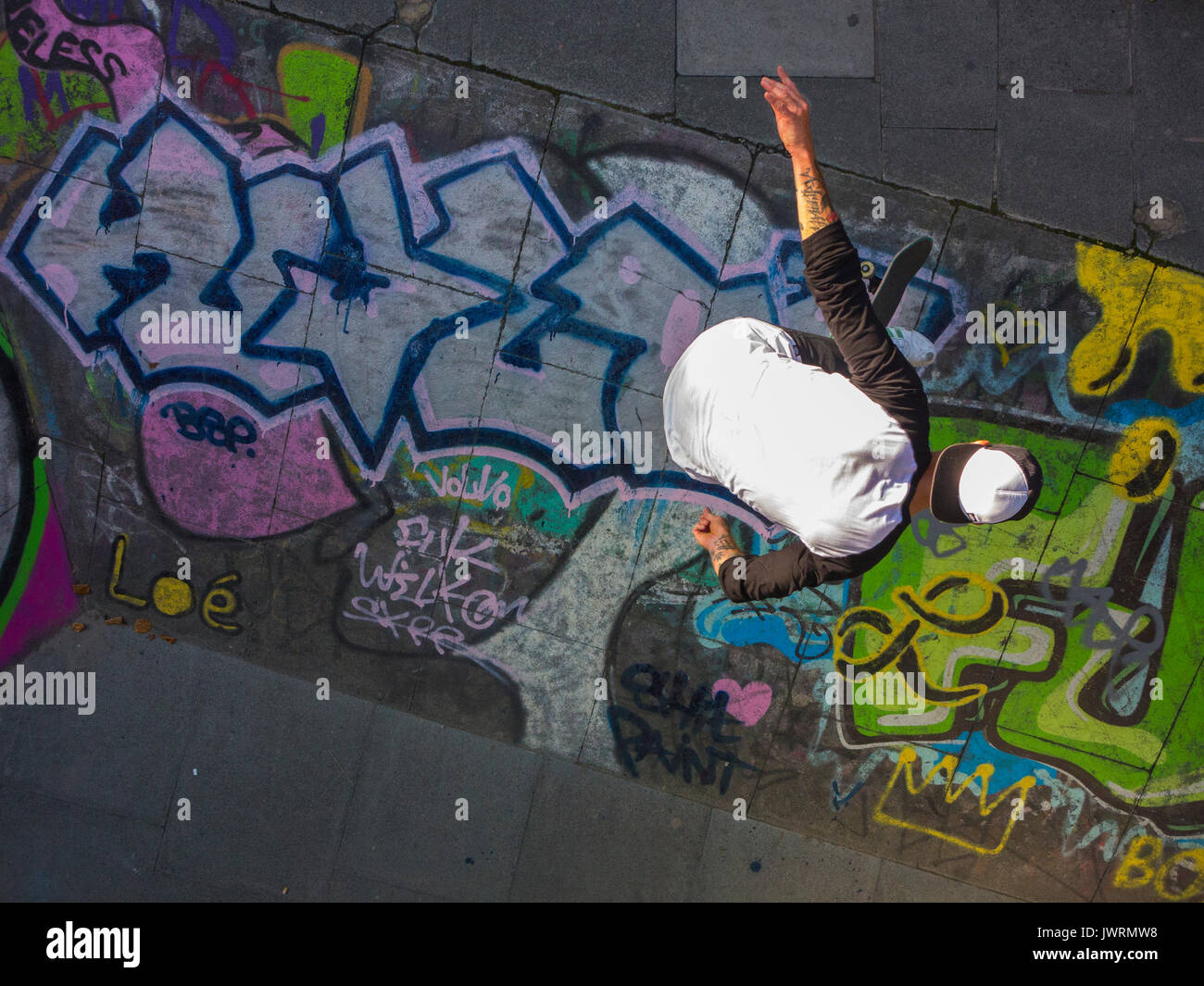 A skateboarder performs a trick, shot from above as an unusual angle Stock Photo