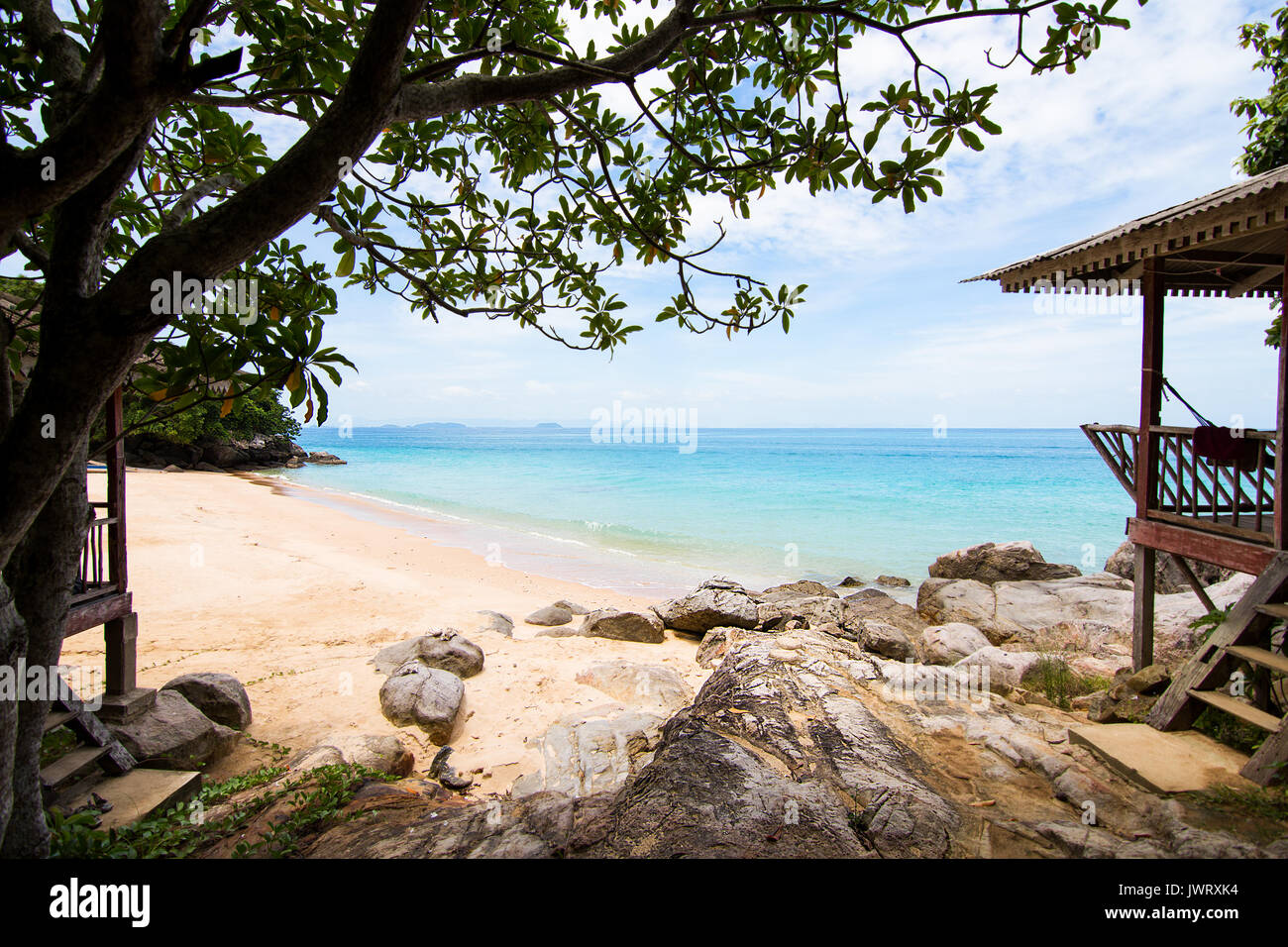Perhentian island, Perfect white sand beach to turquoise sea with wooden beach huts on rocks. Stock Photo