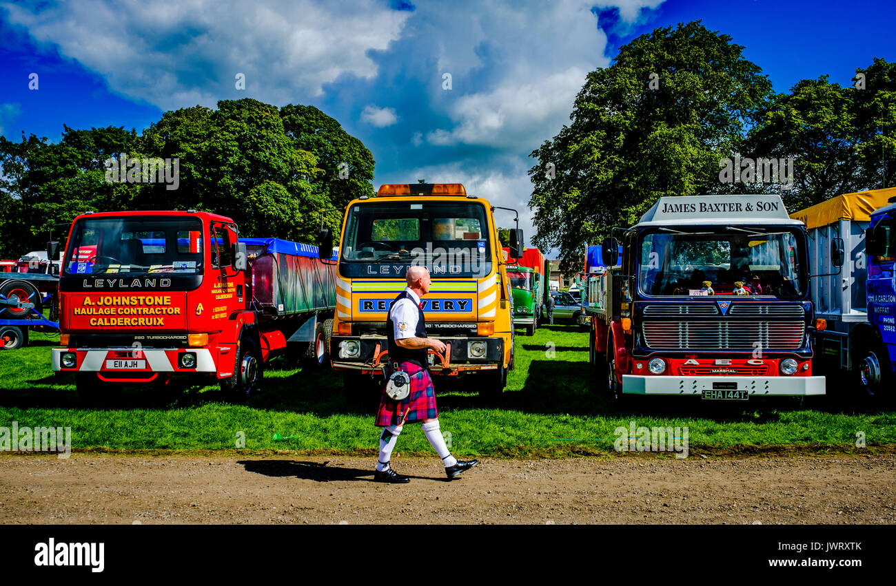 Biggar, South Lanarkshire - 44th Vintage Vehicle Rally. A man in a kilt walks passed a display of vintage lorries. Stock Photo