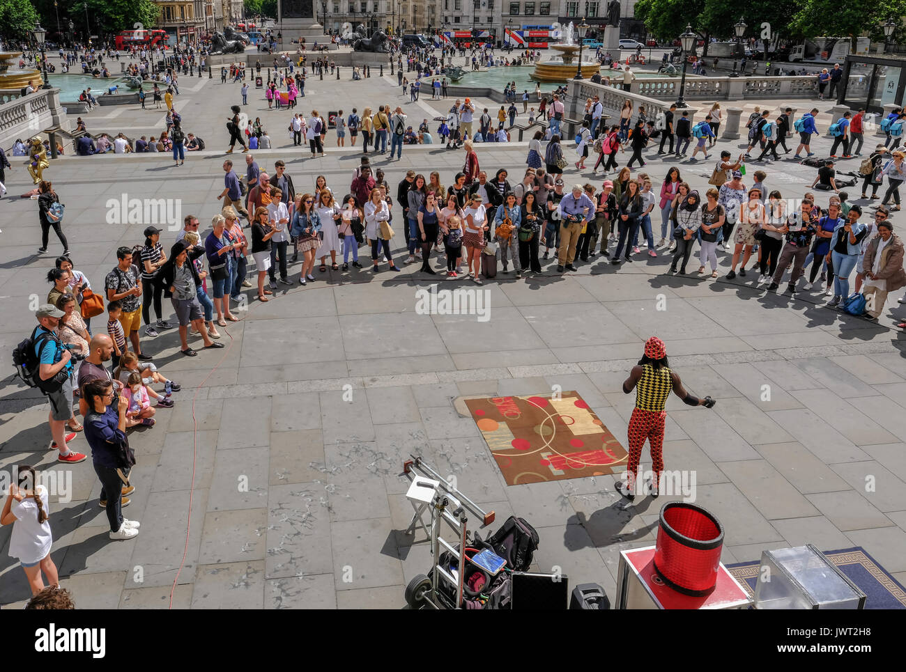 Trafalgar Square, London, UK -  July 21, 2017: Street performer with large crowd watching.  Taken from the National Portrait Gallery, looking down. Stock Photo