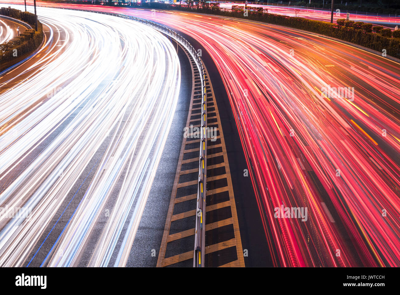 Cars light trails on a curved highway road at night in Chengdu city Stock Photo