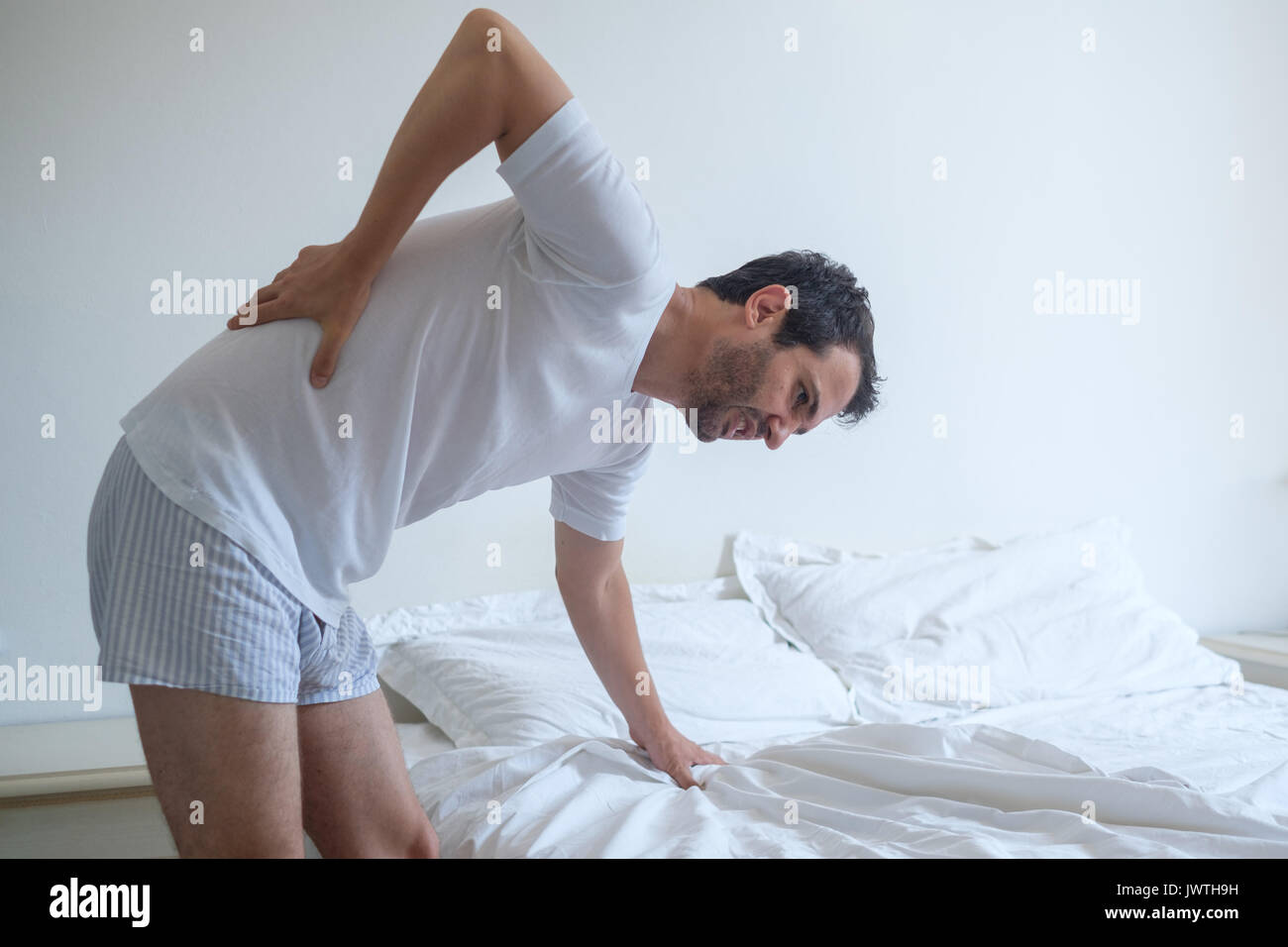 Man feeling back ache in the bed after sleeping Stock Photo Alamy