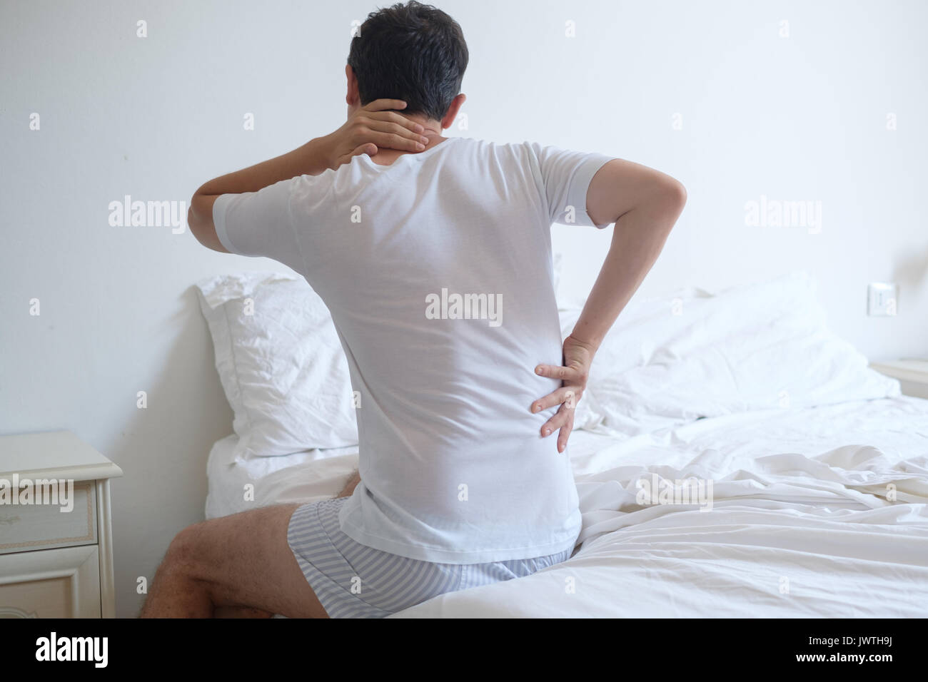 Man feeling back ache in the bed after sleeping Stock Photo Alamy