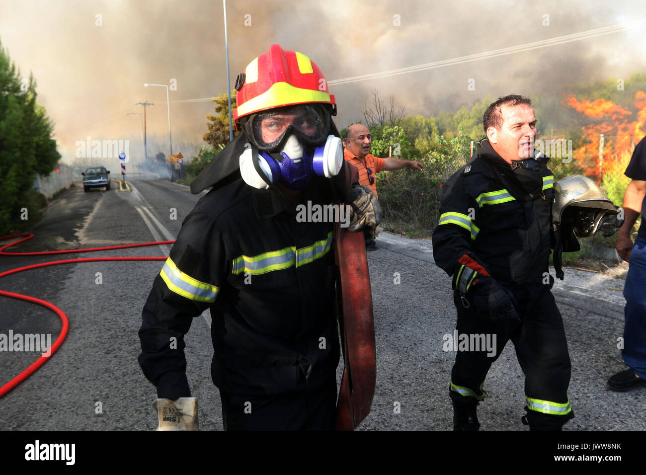 Kalamos Village, Greece. 13th Aug, 2017. Firefighters runs as the forest fire broke out in the village. Credit: SOPA Images Limited/Alamy Live News Stock Photo