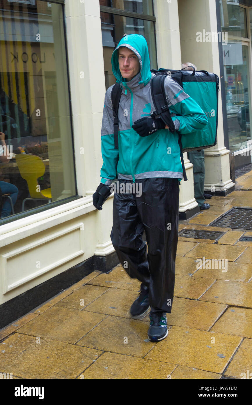Deliveroo courier on foot in the rain in York City Centre Stock Photo