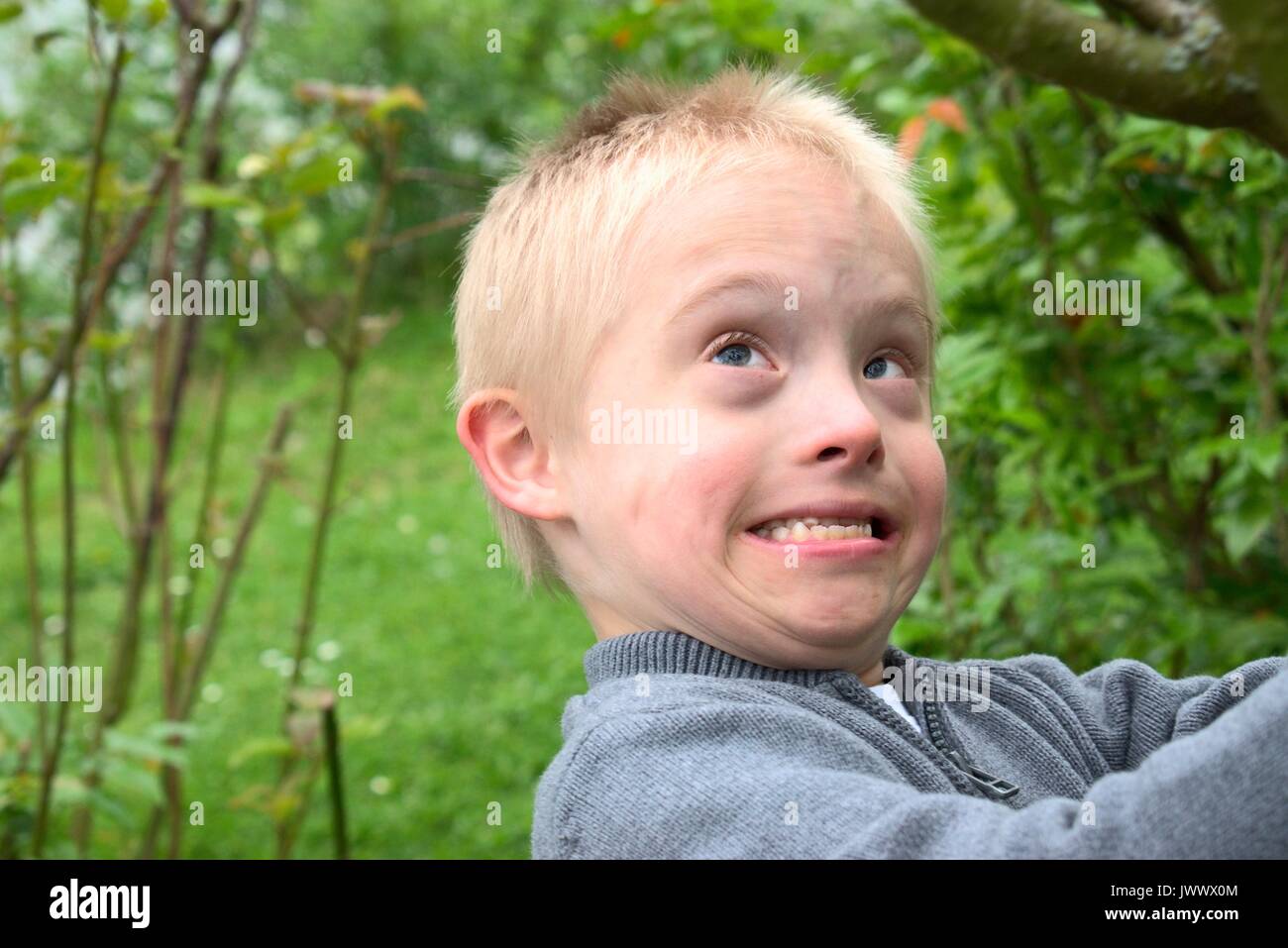 Boy with down syndrome showing his strength. Stock Photo