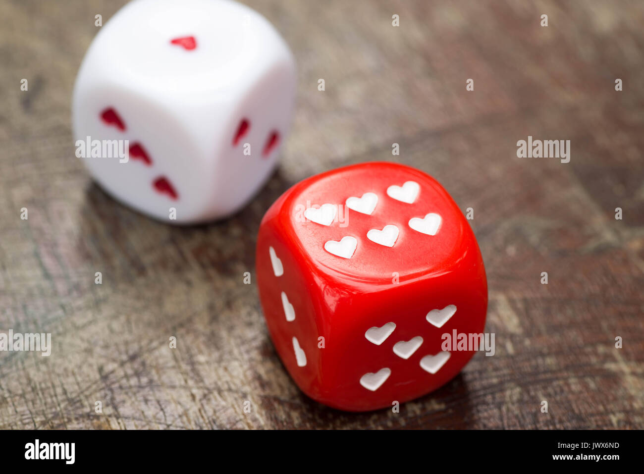 two dices with hearts on wooden table Stock Photo