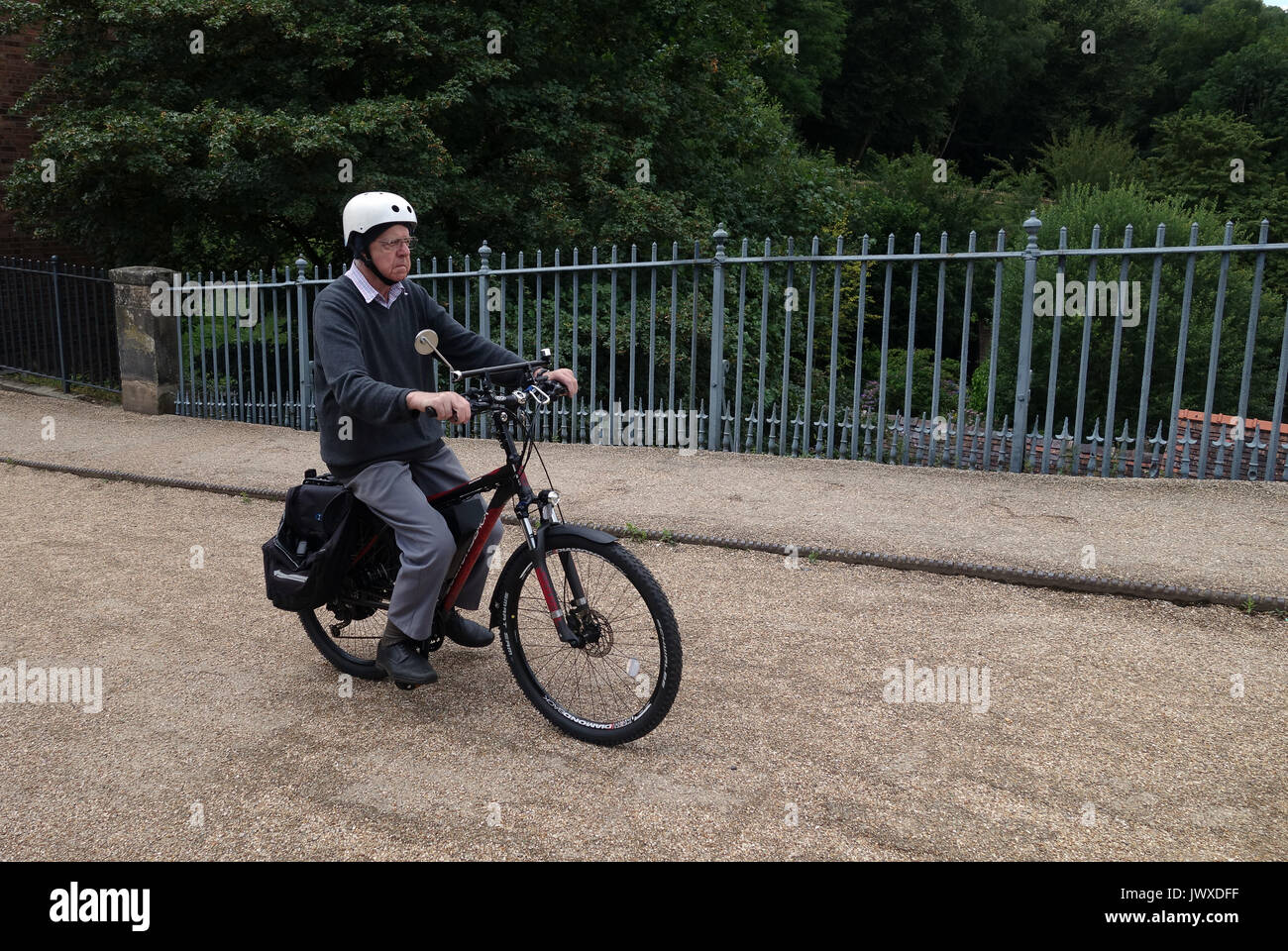 Elderly man riding battery powered electric bicycle Stock Photo