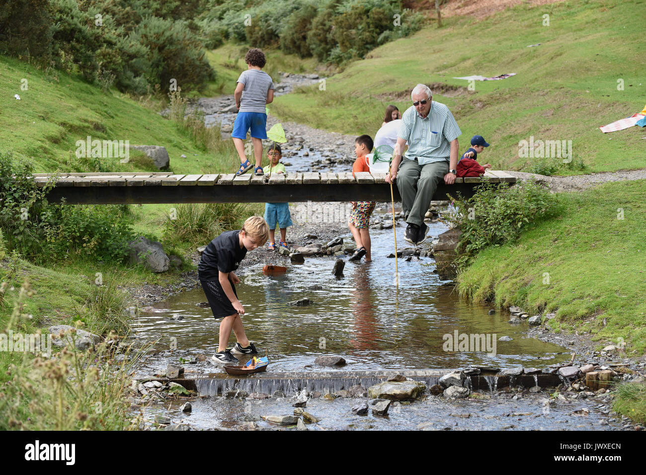 Children playing in stream at Carding Mill Valley in Shropshire Stock Photo