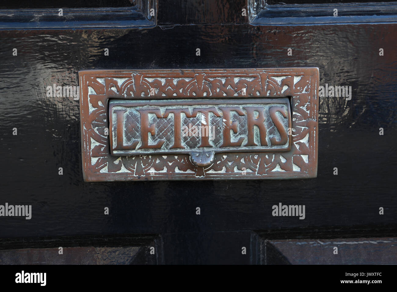 Old Fashioned Bronze Letter Slot On The Black Front Door Of An