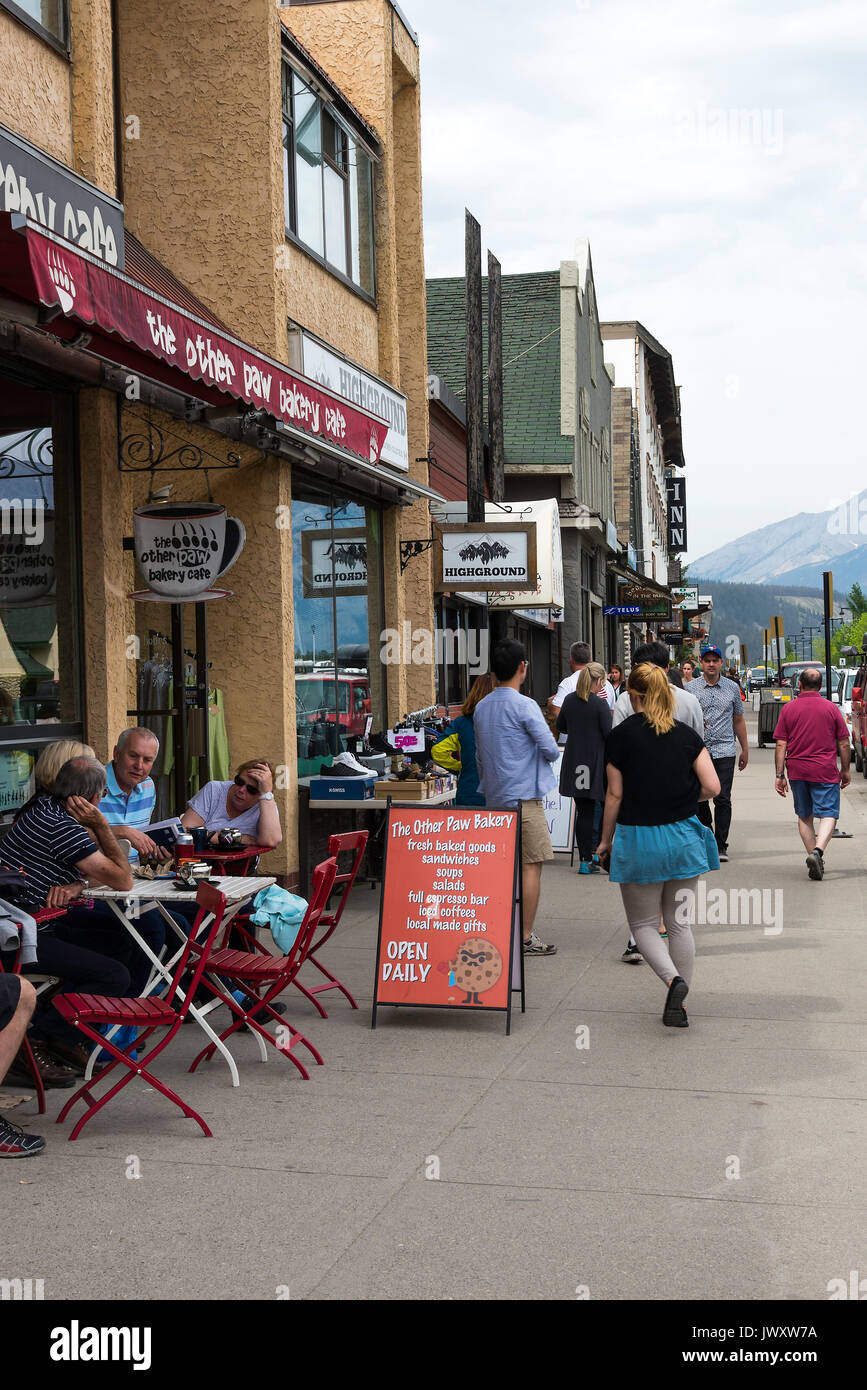 Holidaymakers Exploring Connaught Street and People Eating and Drinking Outside a Bakery in Jasper Alberta Canada Stock Photo