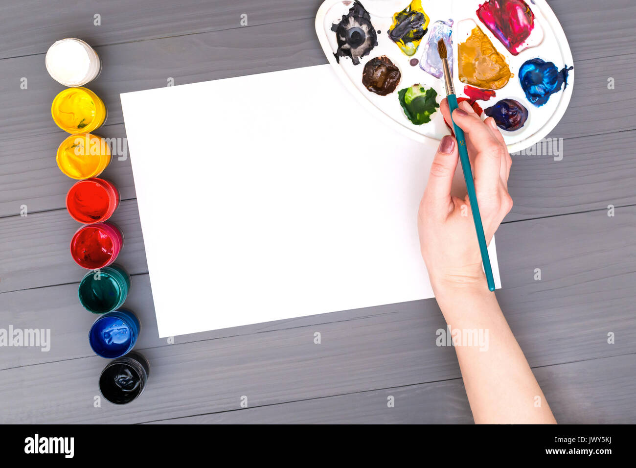 Hand holds brush over sheet Stock Photo Alamy