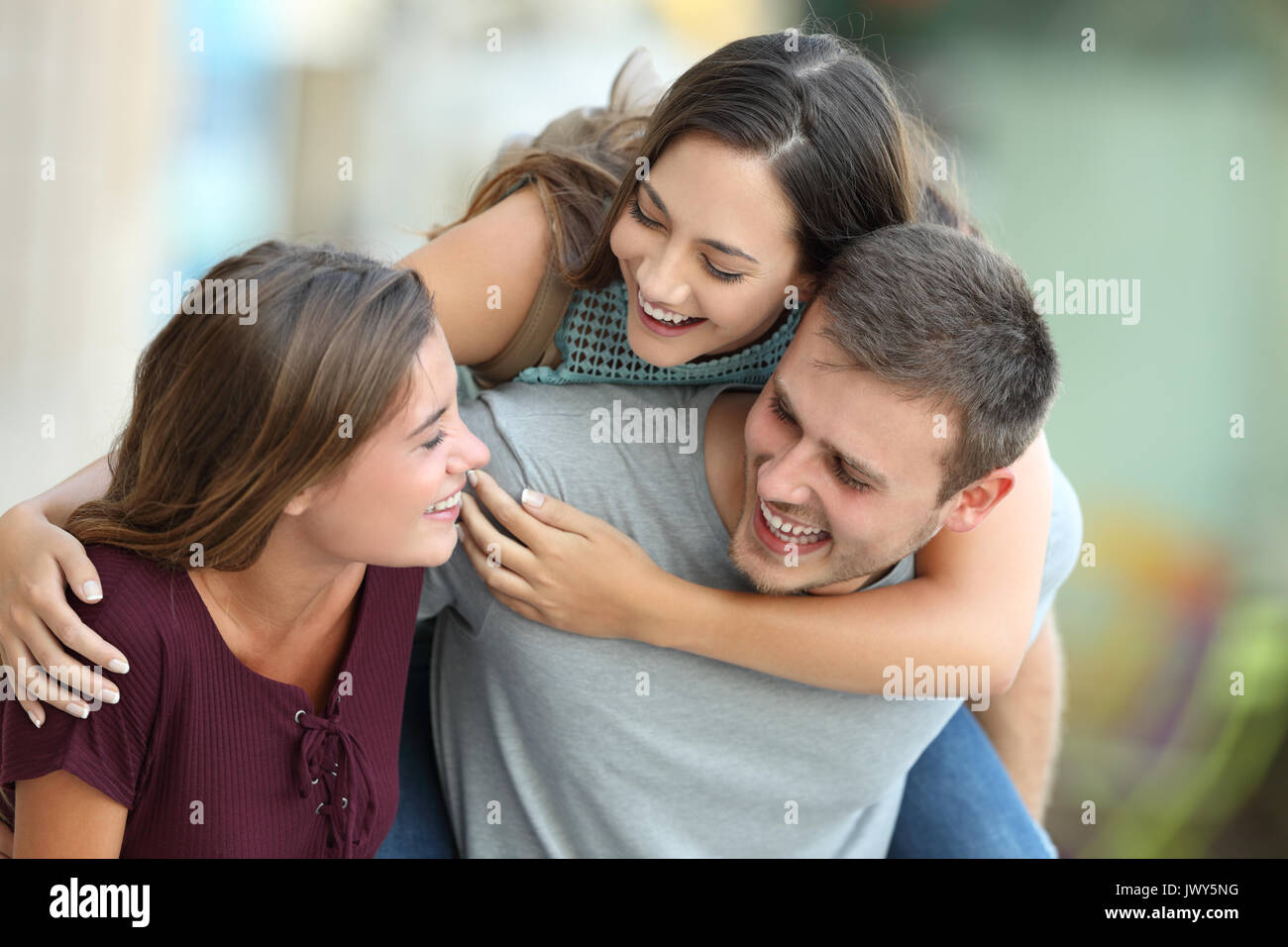 Three happy friends meeting and joking together on the street Stock Photo