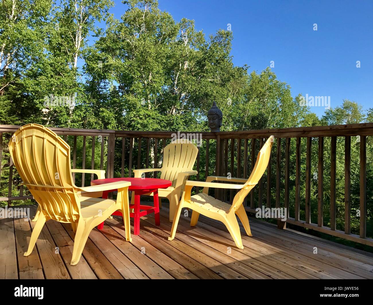 yellow adirondack chairs on a deck in summer Stock Photo Alamy