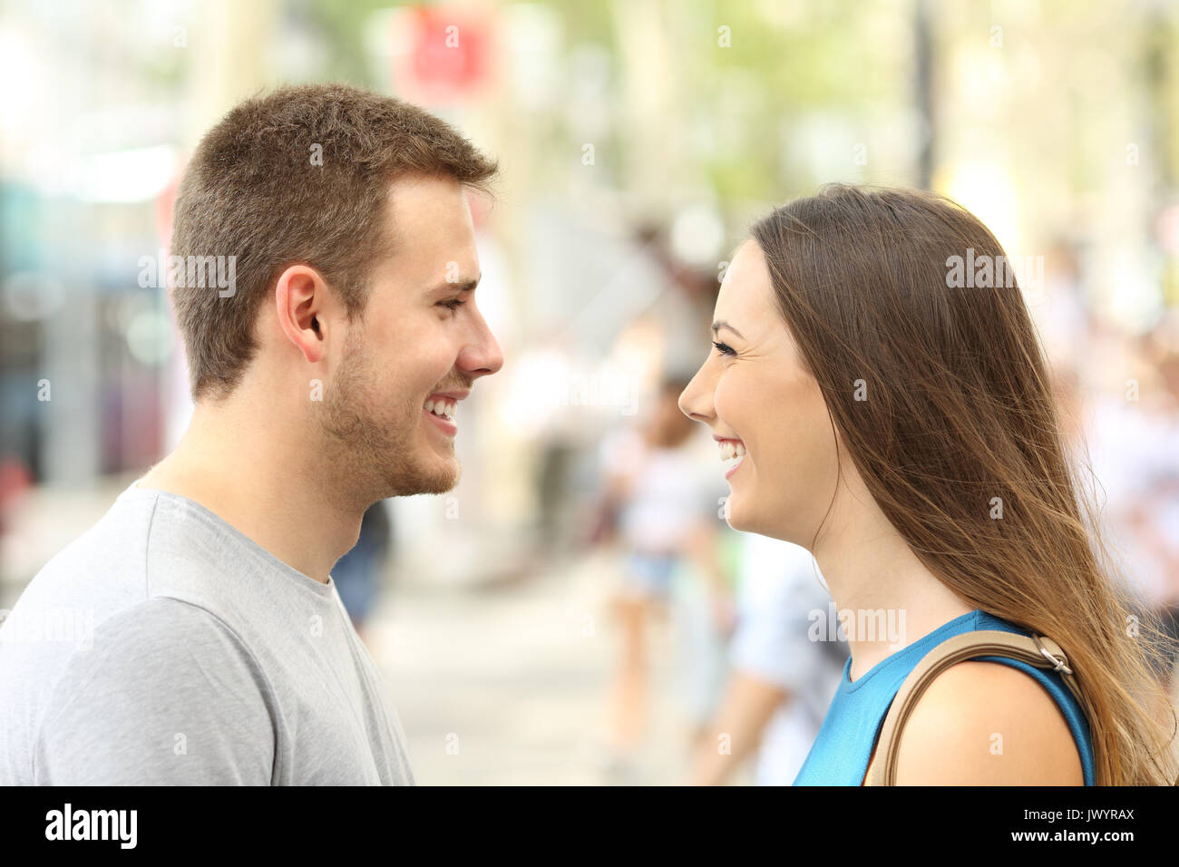 Profile of couple looking each other falling in love on the street Stock Photo