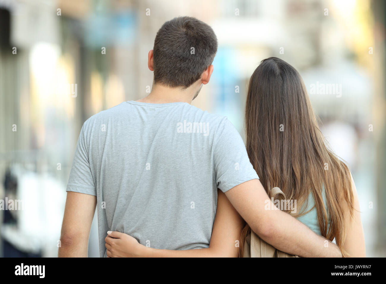 Back view portrait of a casual couple walking together on the street Stock Photo