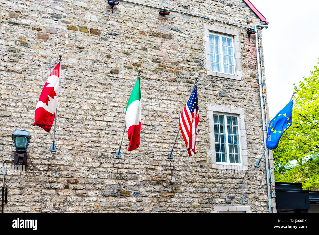Flags of European and North American countries hanging off building, including Canadian, United States, Italian and European Union Stock Photo