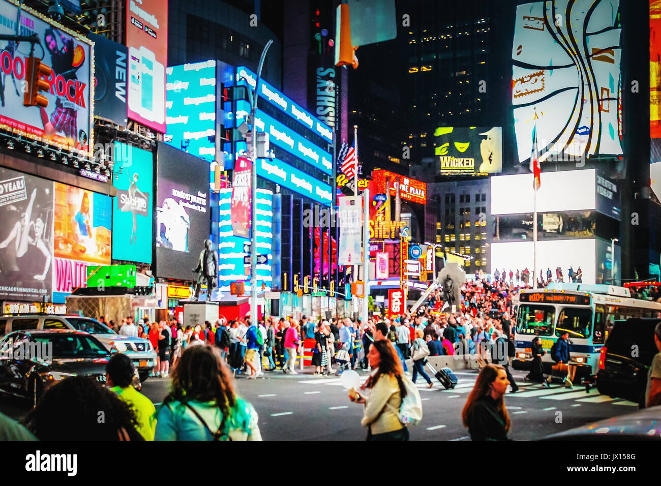 New York, USA - 26 September 2016: Massive advertising Billboards tower above traffic and pedestrians at the intersection between Times Square and Bro Stock Photo