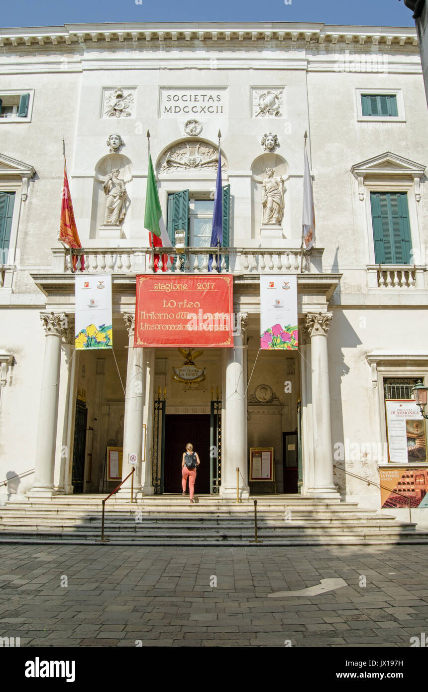 VENICE, ITALY - JUNE 13, 2017:  A woman walking into the historic La Fenice opera house in Venice, Italy on a sunny summer morning. Stock Photo