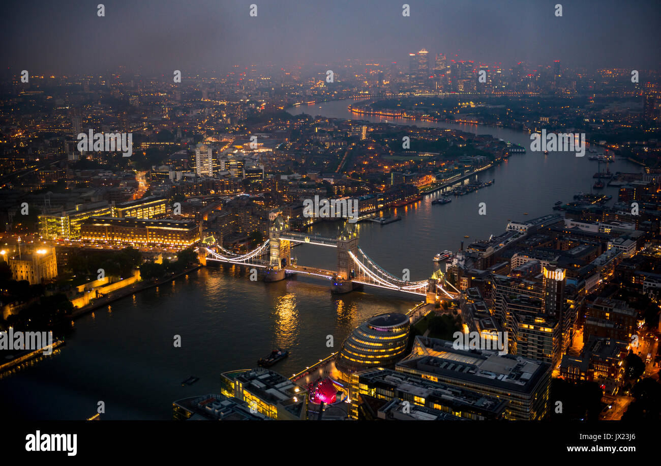 View of River Thames towards Canary Wharf, illuminated Tower Bridge with London City Hall, night shot, aerial view, London Stock Photo